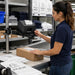 Worker using a Star Micronics printer on an Agoz pole-mount tray at a service workstation and pickup packing station.