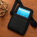 Black Unitech RT112 crossbody carrying case with storage pocket and shoulder strap on a tabletop