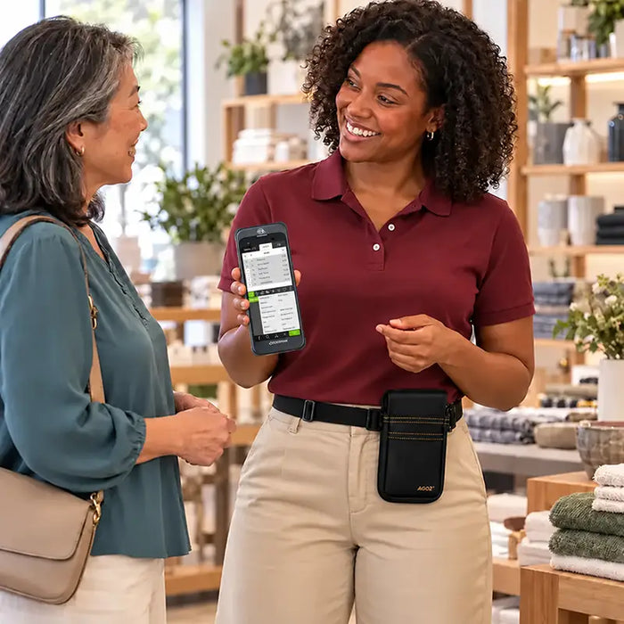 Retail employee wearing a black Agoz Orderman POS waist belt holster while demonstrating a handheld payment terminal to a customer.