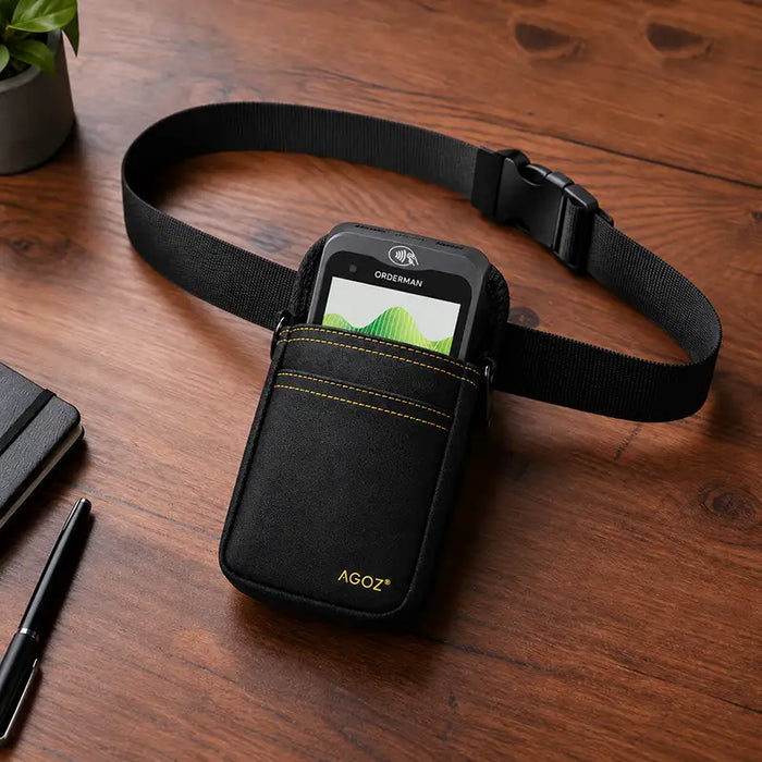 Black Agoz Orderman POS holster with payment terminal, adjustable waist belt, and quick-release buckle displayed on a wooden desk.