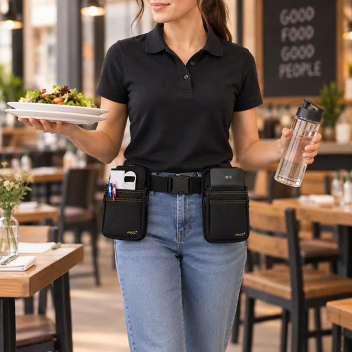 A woman in a restaurant wearing a black POS handheld belt with two front pouches, one holding a white phone and the other holding a pen.