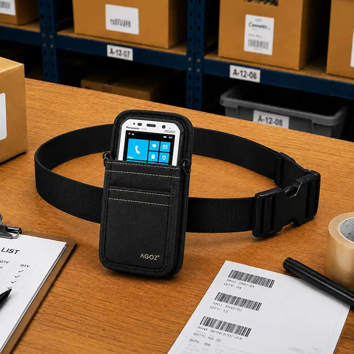 Black Panasonic Toughbook waist belt pouch displayed on a warehouse pick station with barcode labels, pick sheet, tape, and order processing materials.