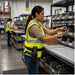 Warehouse worker wearing an AgozTech belt case with handheld scanner while organizing labeled parts bins at an industrial workstation.