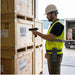 Worker wearing an Agoz waist belt scanner holster while scanning pallet labels on wood crates at a loading dock.