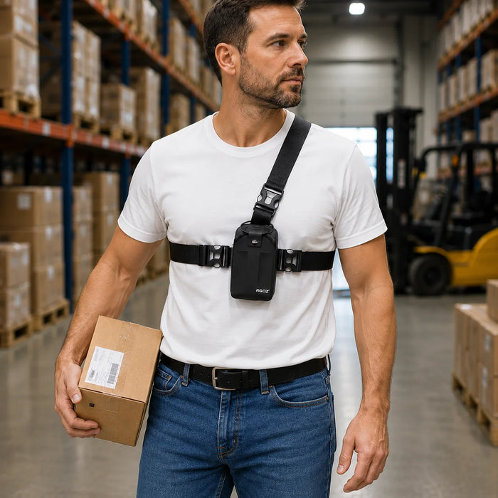 Warehouse worker in a white T-shirt and blue jeans wearing a black AGOZ Zebra handheld chest harness with a compact case while carrying a cardboard box.