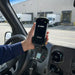 Hand holding Zebra TC77 mobile computer in plugged-in vehicle charger at loading dock