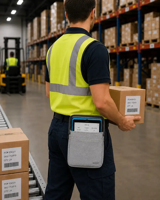 Worker in a warehouse holding a box and using a tablet waist belt case.