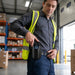Warehouse worker placing a Zebra mobile computer into a black leather belt holster during daily logistics operations.