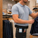 Retail employee wearing an Agoz utility apron with an Elo mobile computer, tools, and accessories secured during store floor work