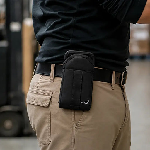 Warehouse worker wearing AgozTech scanner holster on waist belt while using a handheld computer.