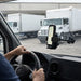 Newland mobile computer mounted on a windshield vehicle cradle holder inside a delivery vehicle near loading trucks.