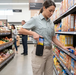 Store employee using AgozTech holster case with Zebra TC53 while stocking shelves