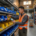 Warehouse worker wearing an AgozTech scanner holster with secure card slot while scanning inventory bins with a Zebra handheld computer.