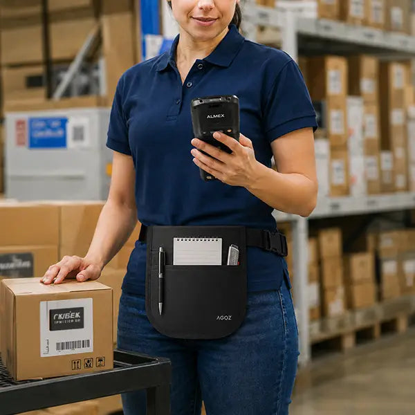 Almex mobile computer utility apron worn by warehouse worker with notepad, pen, and box cutter in front pockets.